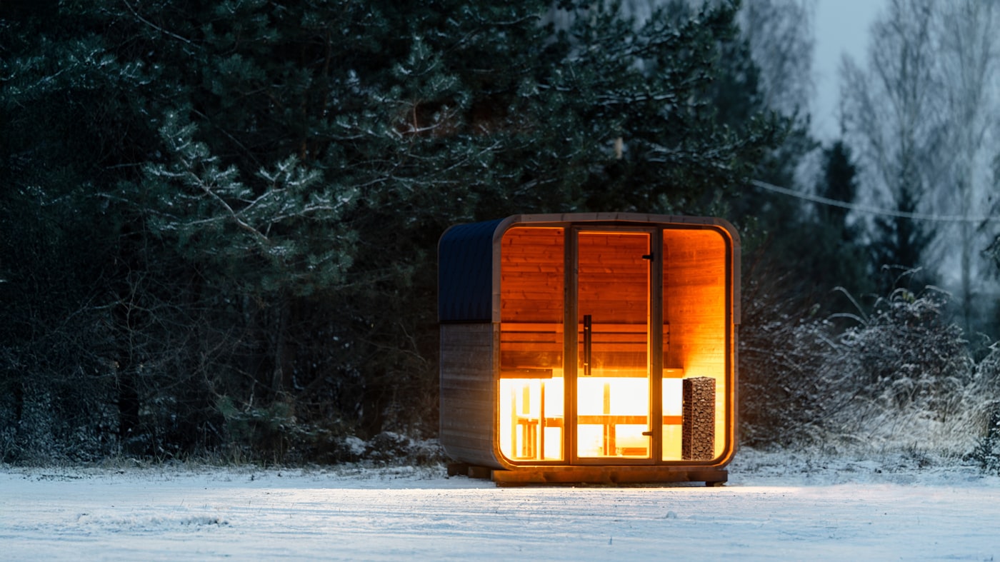 Cedar barrel sauna glowing at dusk
